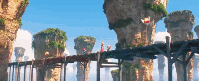 a group of people are walking across a bridge surrounded by floating rocks