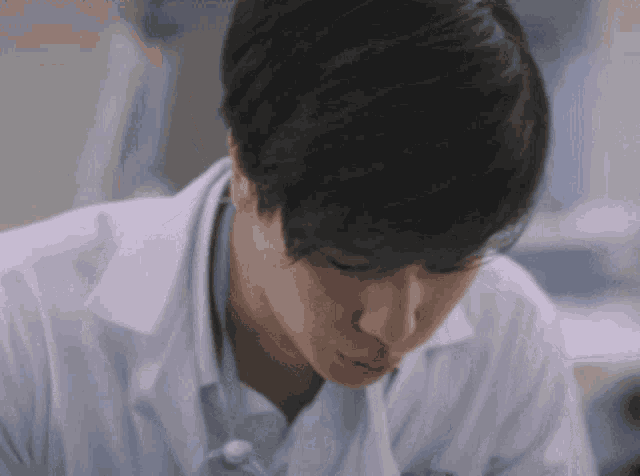 a close up of a man wearing a lab coat