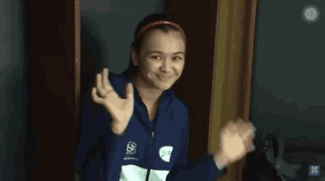 a girl wearing a blue jacket with a rsb logo on it