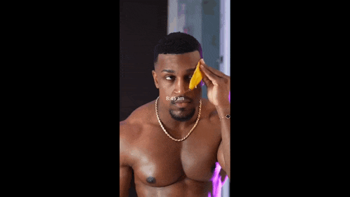 a shirtless man is applying a sponge to his face and the time is 8:45 am