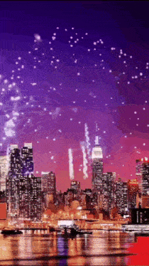 fireworks are displayed over a city skyline with the empire state building in the background