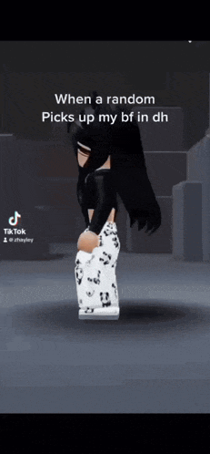 a girl in a black top and white pants is standing in a dark room .