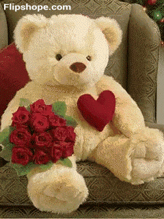 a teddy bear sitting on a couch holding a heart and a bouquet of red roses