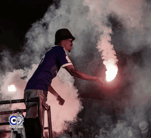 a man holding a flare with the letter c on the bottom