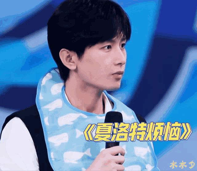 a man wearing a bib is holding a microphone with chinese writing on it