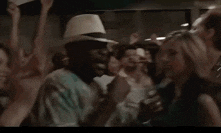 a man in a white hat is dancing in a crowd