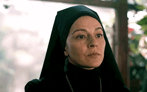 a close up of a woman wearing a black veil and a necklace