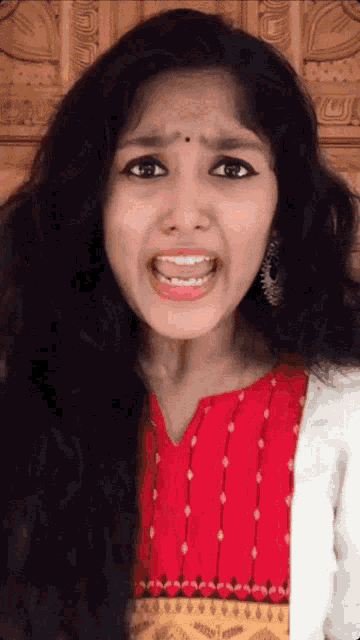 a woman making a funny face wearing a red shirt