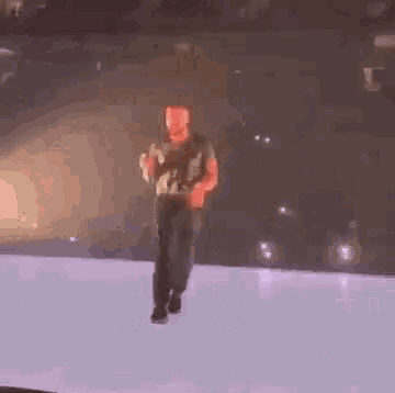a man is dancing on a stage with a microphone in his hand .