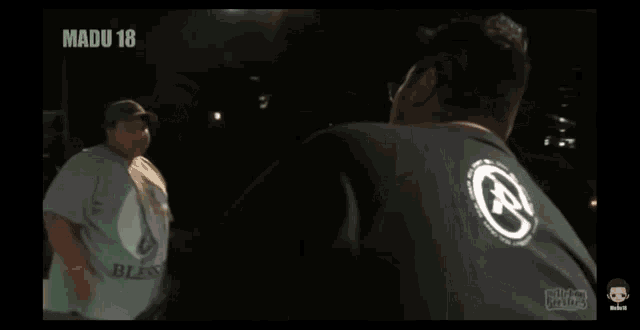 a man singing into a microphone with madu 18 written on the bottom of the screen