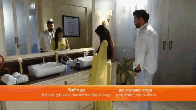 a man and a woman are standing in a bathroom with a sign that says ' a ' on it