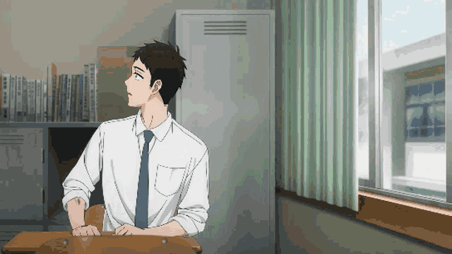 a man in a white shirt and tie sits at a desk looking out a window