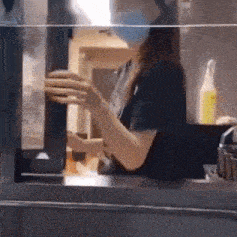 a woman wearing a mask is working in a restaurant .