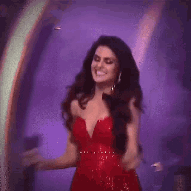 a woman in a red dress is standing on a stage with a microphone in her hand .