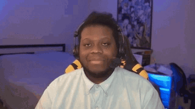 a man wearing headphones is sitting in front of a bed