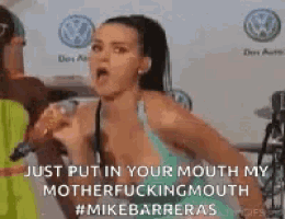 a woman is making a funny face while holding a microphone in her mouth .