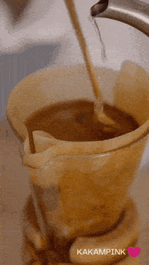 a cup of coffee is being poured into a filter with the words kakampink written on the bottom