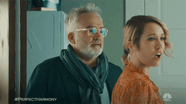 a man and a woman are standing next to each other with a nbc logo in the corner