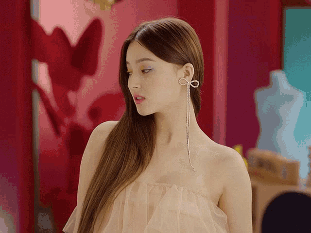 a woman in a strapless dress has a bow earring