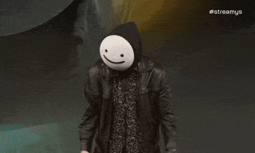 a man wearing a mask with a smiley face on it is holding a microphone