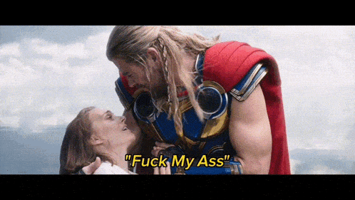 a man in a superhero costume is kissing a woman with the words " fuck my ass " written above them