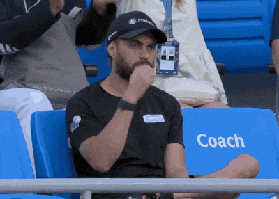 a man is sitting in a stadium with a coach seat