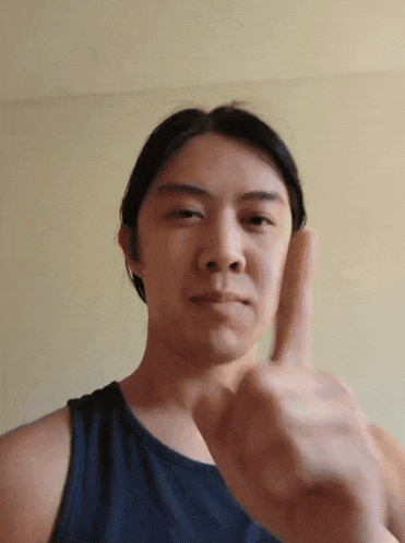a man in a black tank top is giving a thumbs up sign