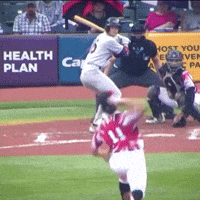 a baseball game is being played in front of a health plan advertisement