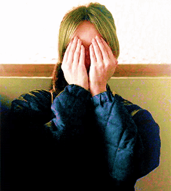 a person covering their face with their hands in a blurry photo