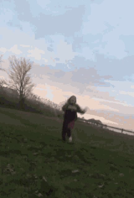 a blurry picture of a person running in a field with a sunset in the background