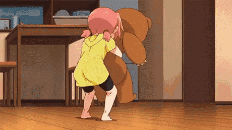 a girl in a yellow shirt is hugging a brown teddy bear in a living room .