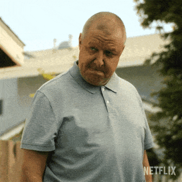a man wearing a netflix shirt is making a funny face