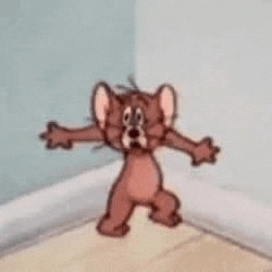 jerry from tom and jerry is standing in a corner of a room .
