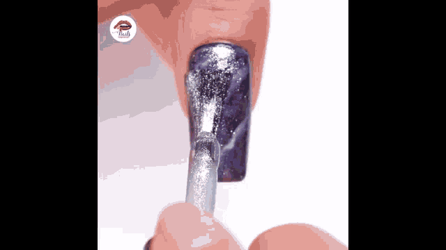 a close up of a person applying nail polish to their nails with a brush .