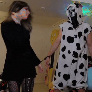 a man in a cow costume is being held by a woman