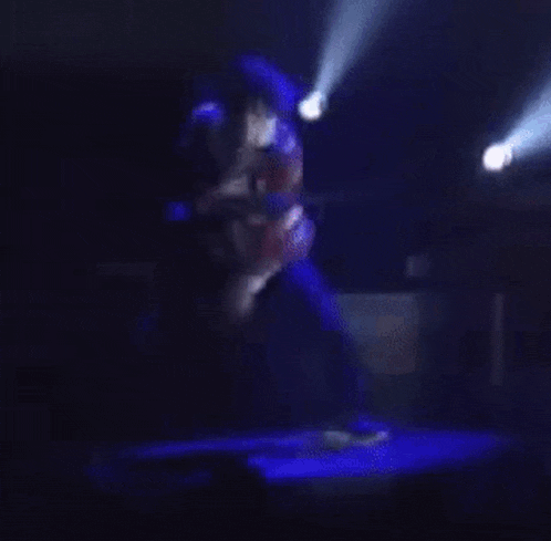a man is dancing on a stage in front of a crowd .