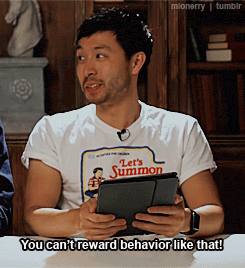 a man wearing a let 's summon t-shirt holds a tablet