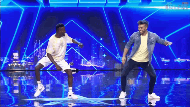 two men are dancing on a stage in front of a sign that says talent