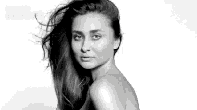 a black and white photo of a woman without a shirt on .