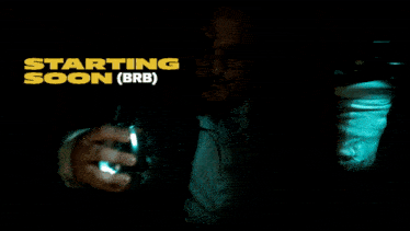 a man in a dark room with the words starting soon ( brb )