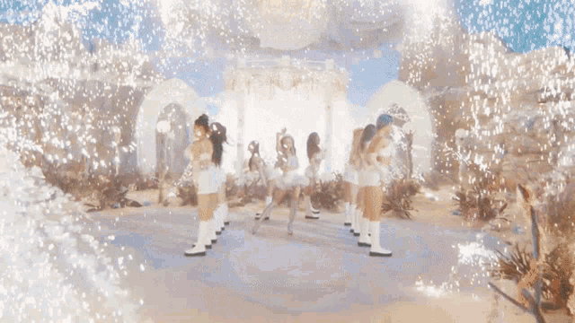 a group of women are dancing in front of a building with fireworks coming out of it