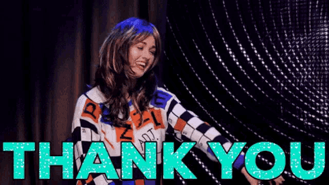 a woman in a wig is standing on a stage with the words `` thank you '' behind her .