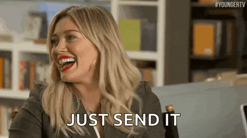 a woman is laughing while sitting in a chair and saying `` just send it '' .