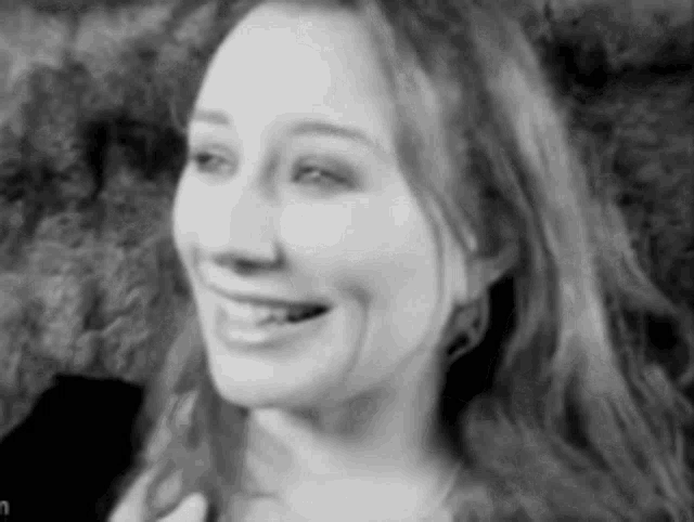 a black and white photo of a smiling woman