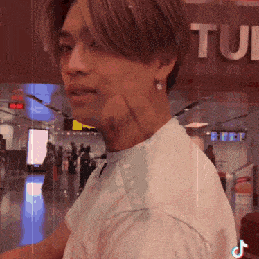 a man in a white shirt stands in front of a sign that says tui