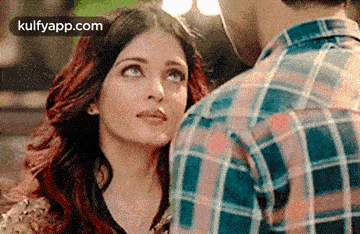 a man and a woman are looking at each other and the woman is looking up at the man .