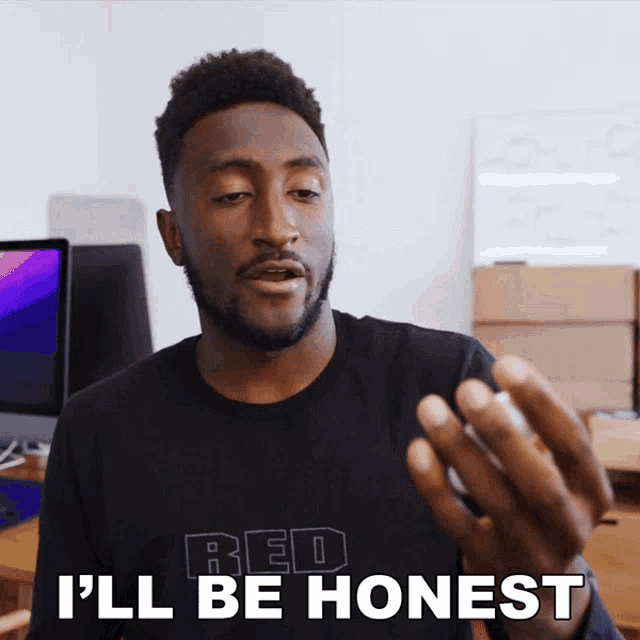 a man wearing a black shirt that says red on it says i 'll be honest