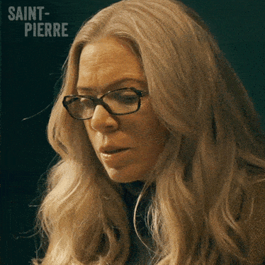 a blonde woman wearing glasses with the name saint-pierre behind her