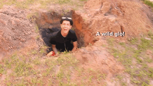 a man is crawling out of a hole with the words " a wild gio " written above him