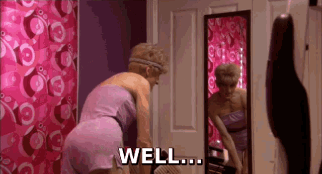 a woman in a purple dress is looking at herself in a mirror and the word well is visible